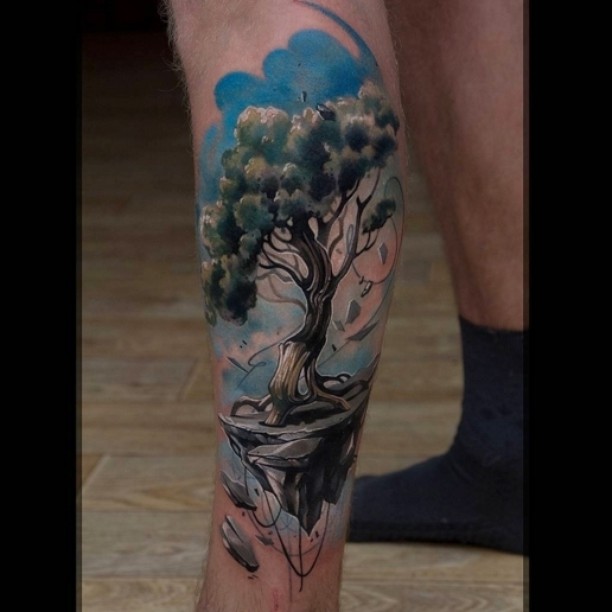 a beautiful tree on the clif on the blue sky background - tattoo on calf