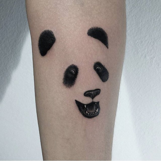 face of panda tattoo on arm.