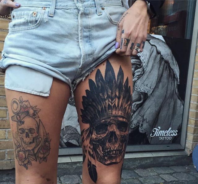 skull feathers tattoo on thigh