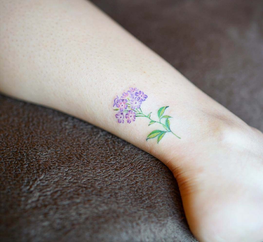 Lilac flower tattoo located on the ankle,