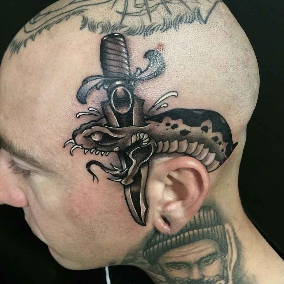 stabbed black snake tattoo on head