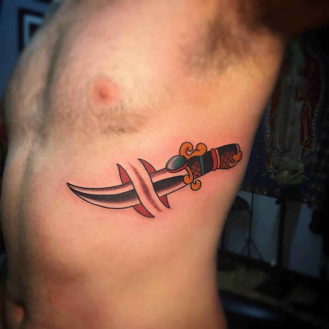 ribs tattoo of dagger under the skin