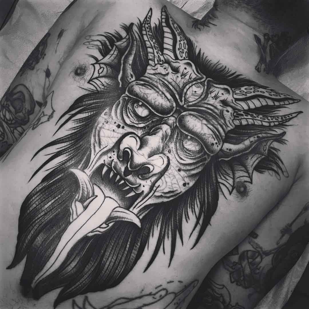 demon face tattoo on chest and stomach