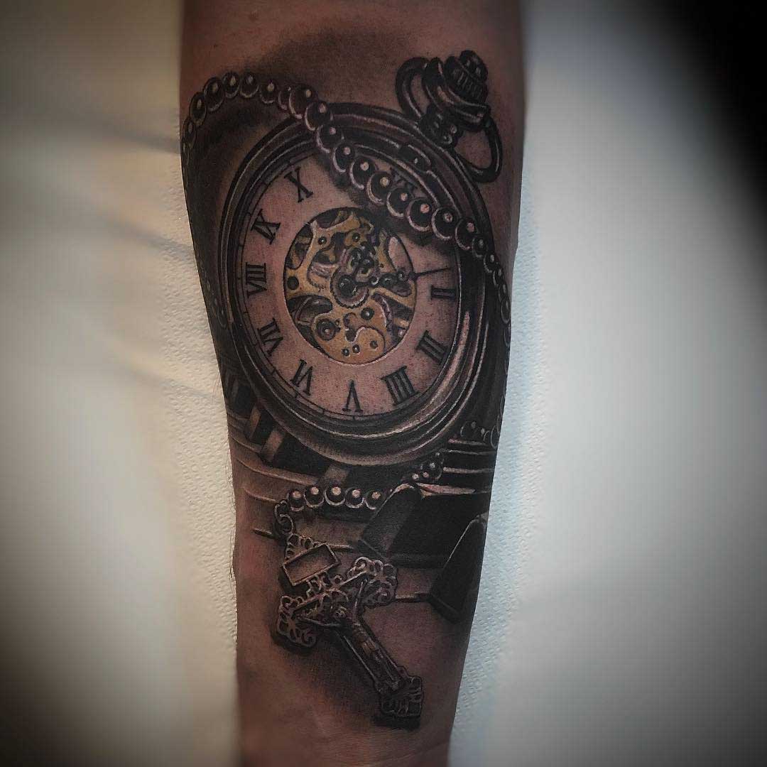 religious crux and pocket watch tattoo on arm