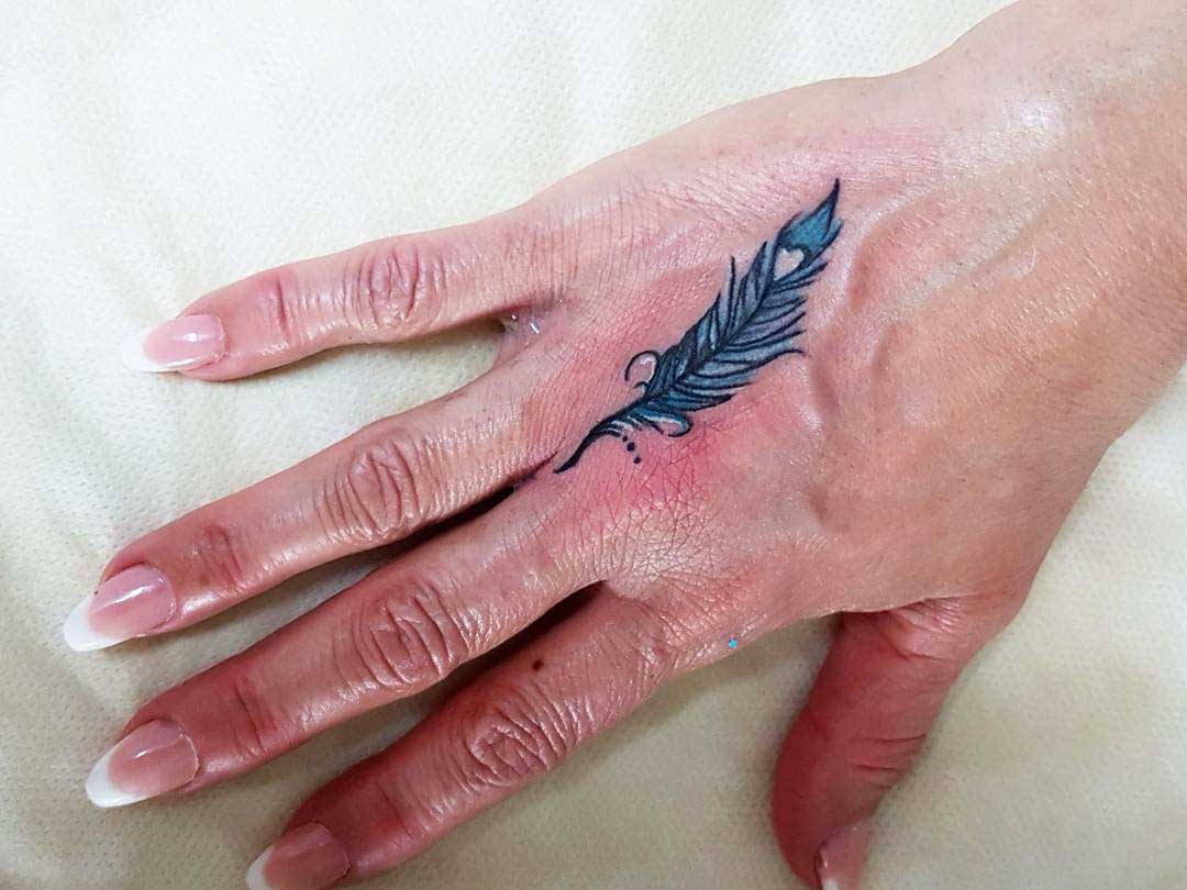 hand tattoo feather