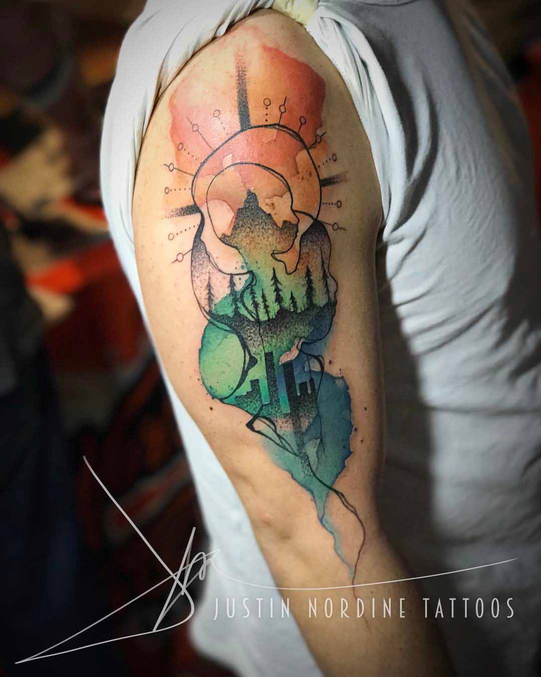 watercolor style nature and city tattoo on shoulder