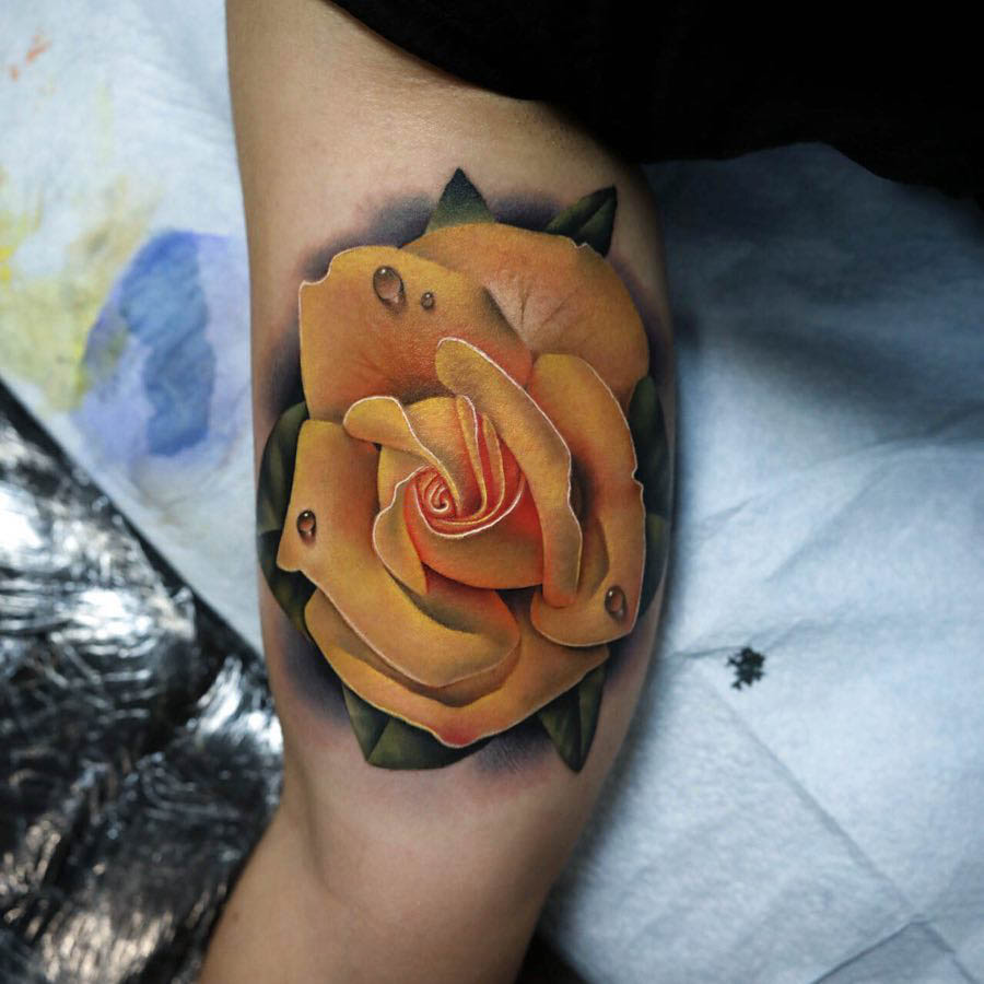 Realistic yellow rose tattoo on the forearm
