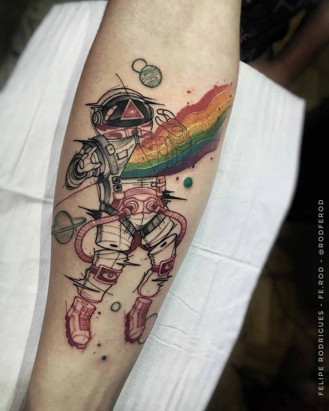 arm tattoo astronaut and rainbow